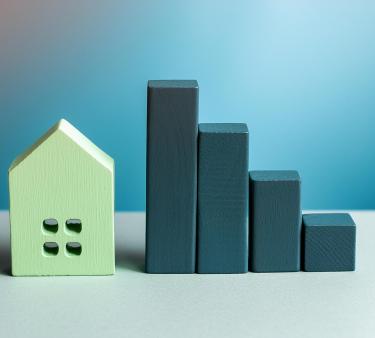 Puupalikoilla kasattu tilastokuvio ja asuntoa esittävä puukoriste.