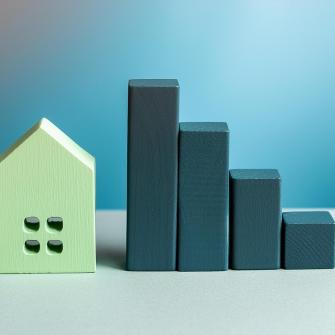 Puupalikoilla kasattu tilastokuvio ja asuntoa esittävä puukoriste.