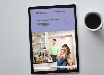 Asumisneuvonta Suomessa -julkaisun kansilehti näkyy työpöydällä olevan tablettitietokoneen ruudulla.